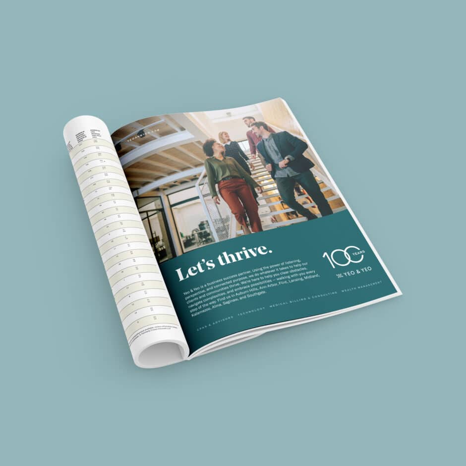 Magazine open to an ad showing four diverse people conversing on stairs in a modern office. Text reads “Let’s thrive” with “100 years”, conveying growth.