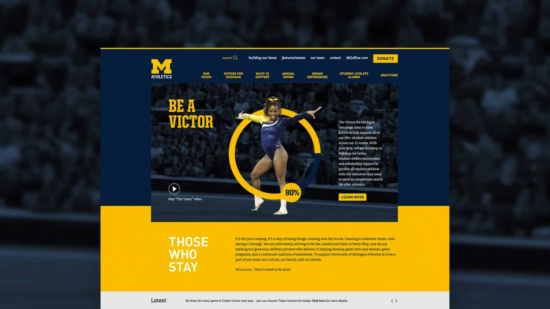 A gymnast in a blue leotard strikes a confident pose on a blue and yellow University of Michigan athletics webpage. Text reads "Be a Victor" and "Those Who Stay."
