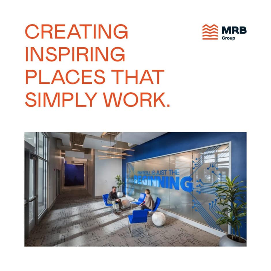 Office lobby with modern design; blue chairs, round tables, plants, and a blue accent wall with motivational text. Bright and welcoming atmosphere.
