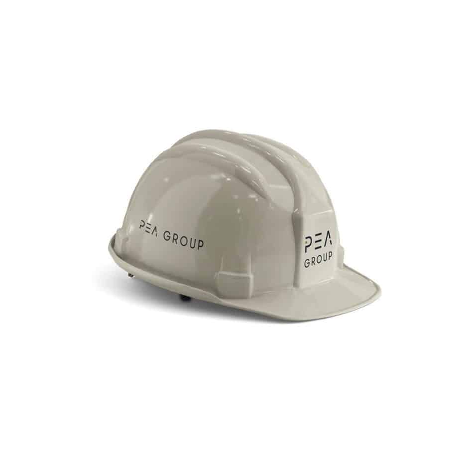 A white hard hat with "PEA GROUP" printed on both sides. It has a sleek, glossy finish and is shown against a plain, white background.