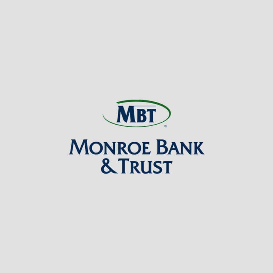 Logo for Monroe Bank & Trust featuring the initials "MBT" in blue with a green oval above the full name in bold blue letters on a light gray background.