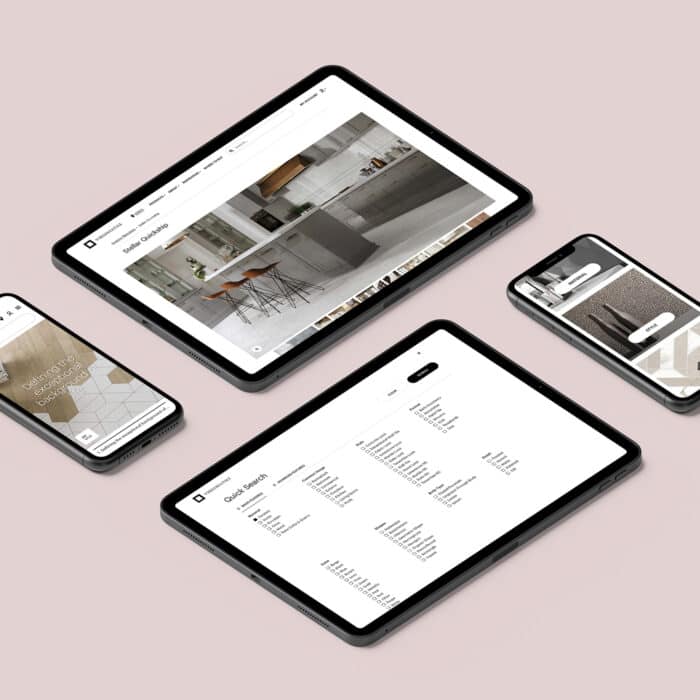 Four digital devices, including tablets and smartphones, display various interior design websites on a soft pink surface, conveying modern technology and style.