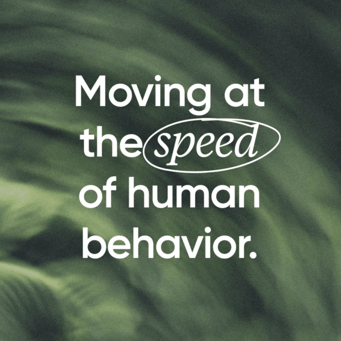 Text reading "Moving at the speed of human behavior." on a blurred green background. The word "speed" is emphasized with an oval around it.
