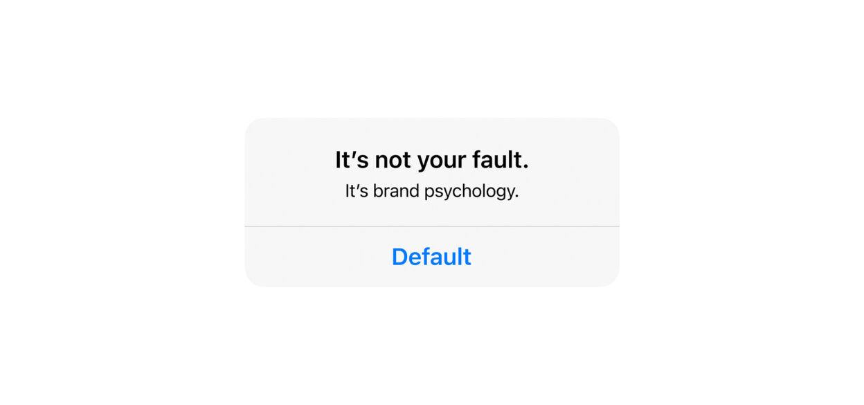 Text on a white background reads, "It’s not your fault. It’s brand psychology." Below is the word "Default" in blue, resembling a clickable button.
