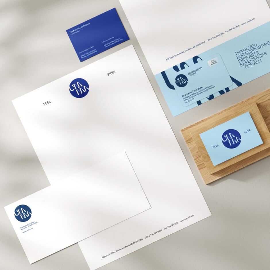 A minimalist stationery set on a light surface, featuring letterheads, envelopes, and business cards with a blue swirl logo and text, evoking professionalism.