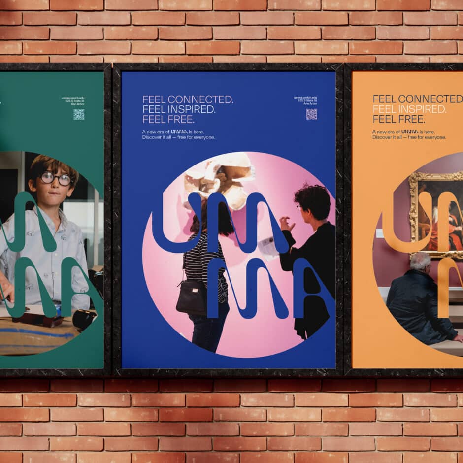 Three colorful posters are displayed on a brick wall. They have bold designs with overlapping text and people engaged in creative activities. The text reads "Feel Connected. Feel Inspired. Feel Free."