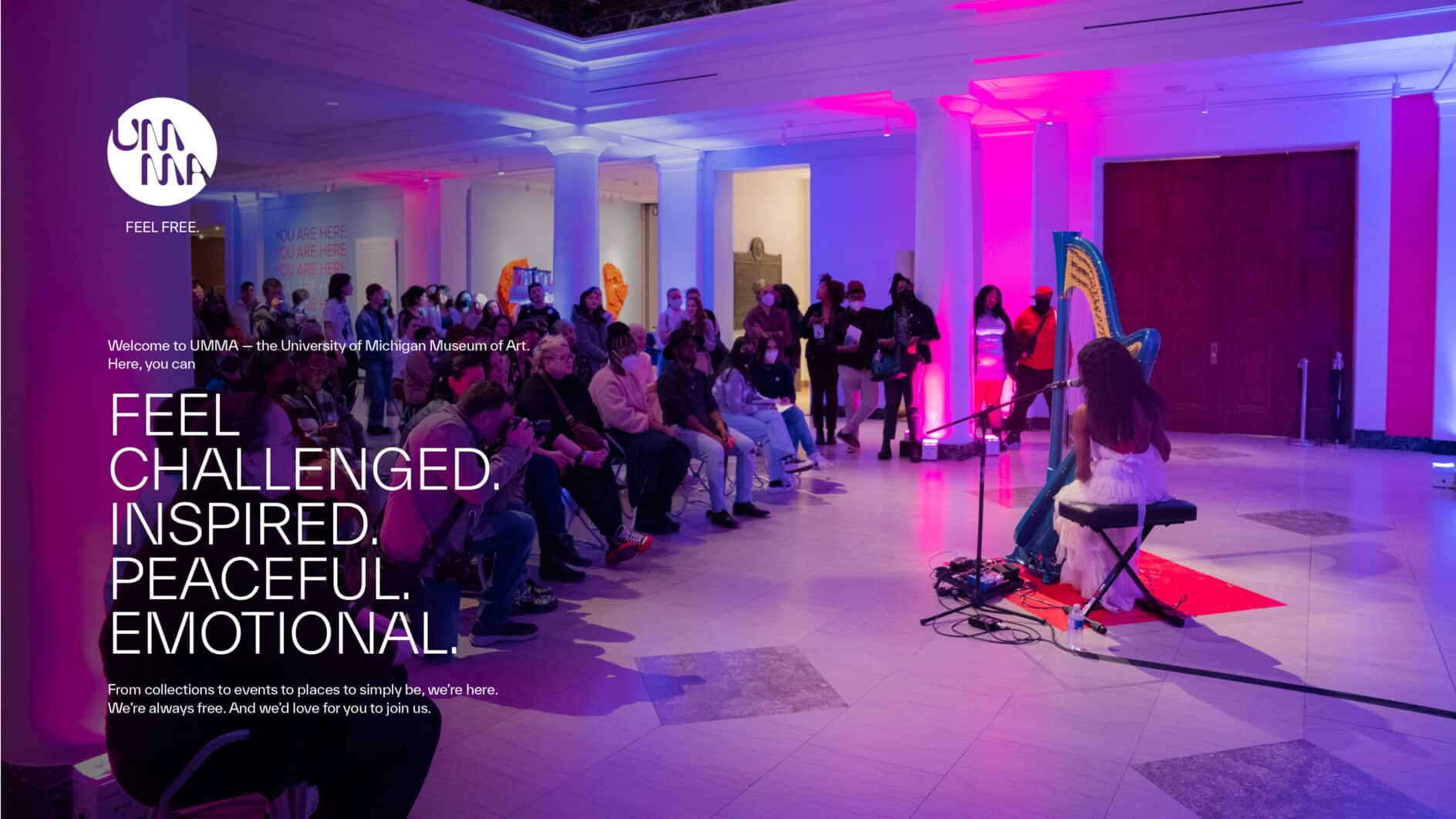 A harpist performs in a vibrant gallery with pink and blue lighting. An audience is seated, attentively watching, creating a lively and engaged atmosphere. Text overlay reads: "Feel challenged. Inspired. Peaceful. Emotional."