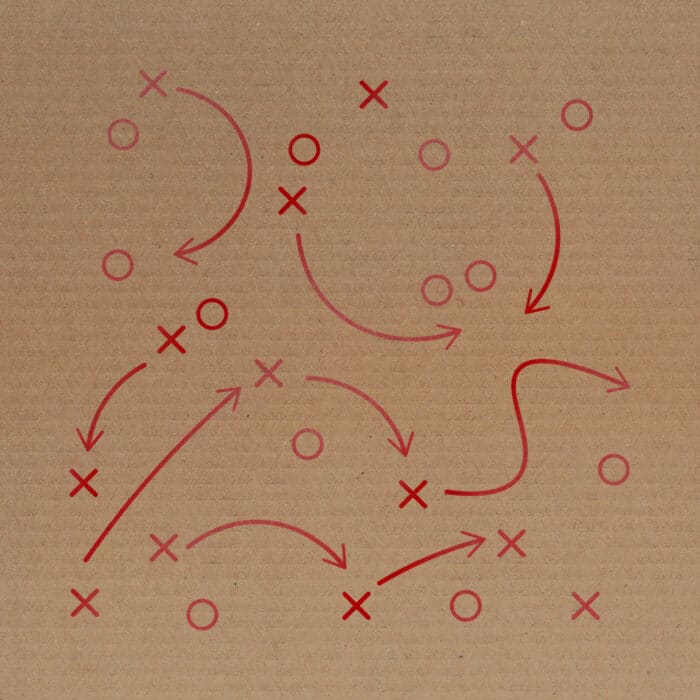 Patterned background with red Xs, Os, arrows, and curved lines on a brown paper texture, resembling a sports or strategy play diagram.