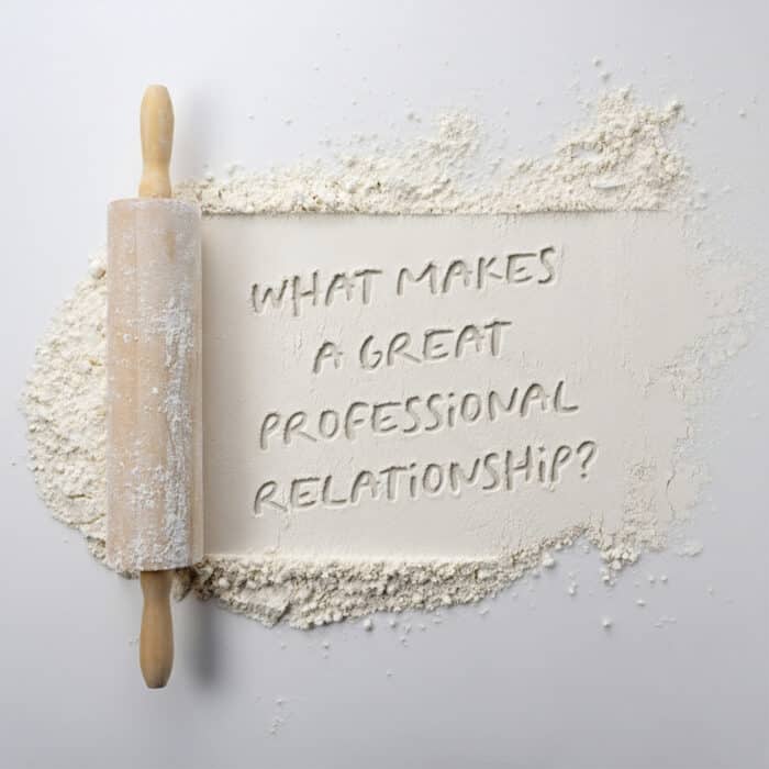 A wooden rolling pin dusted with flour lies on a white surface. Flour surrounds the central text, "What makes a great professional relationship?"