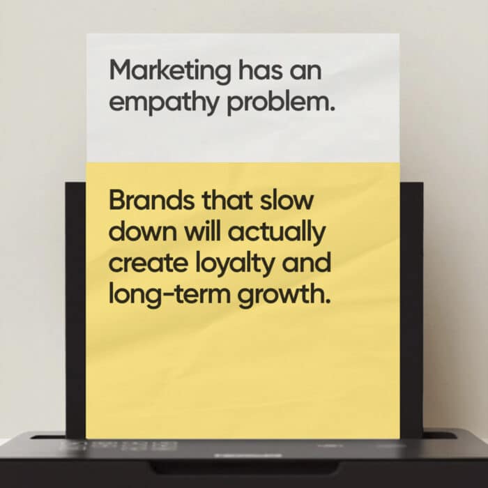 A printer ejects a page with two sections. Top: "Marketing has an empathy problem." Bottom: "Brands that slow down will create loyalty and long-term growth."