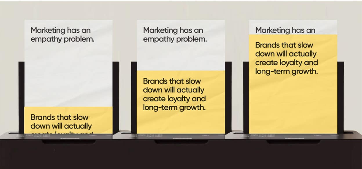 Three posters with text read, "Marketing has an empathy problem. Brands that slow down will actually create loyalty and long-term growth," on a black shelf.
