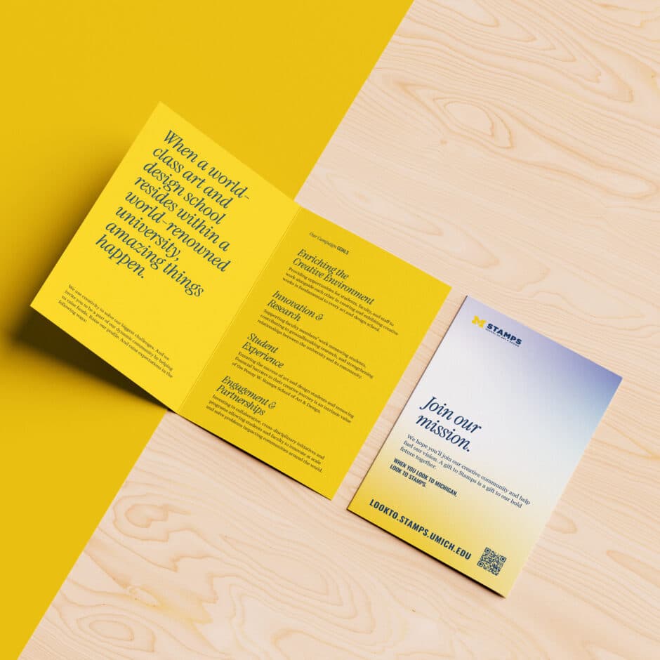 A yellow and white brochure with text about a creative arts program. The open section has dark text on a yellow background, while the cover features a gradient from blue to yellow with "Join our mission" prominently displayed. The brochure is set on a light wooden surface, conveying a modern and inviting tone.