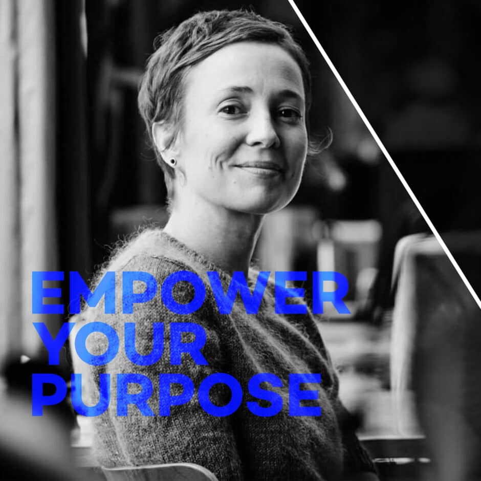 A woman with short hair smiles confidently in a black-and-white setting. Bold blue text reads "Empower Your Purpose," conveying motivation and empowerment.
