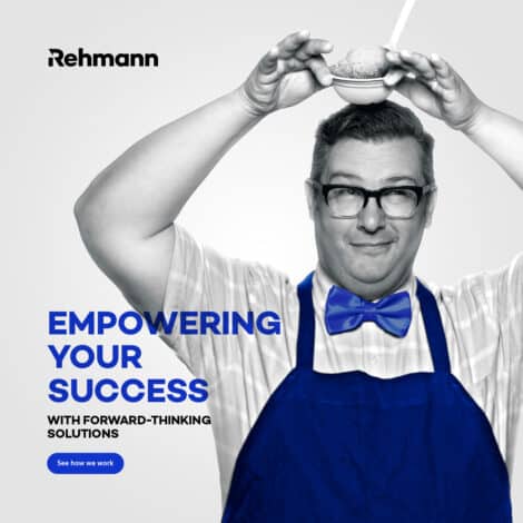 A cheerful man in glasses, wearing a blue apron and bow tie, holds a bowl with a small sphere above his head. Text reads "Empowering Your Success."