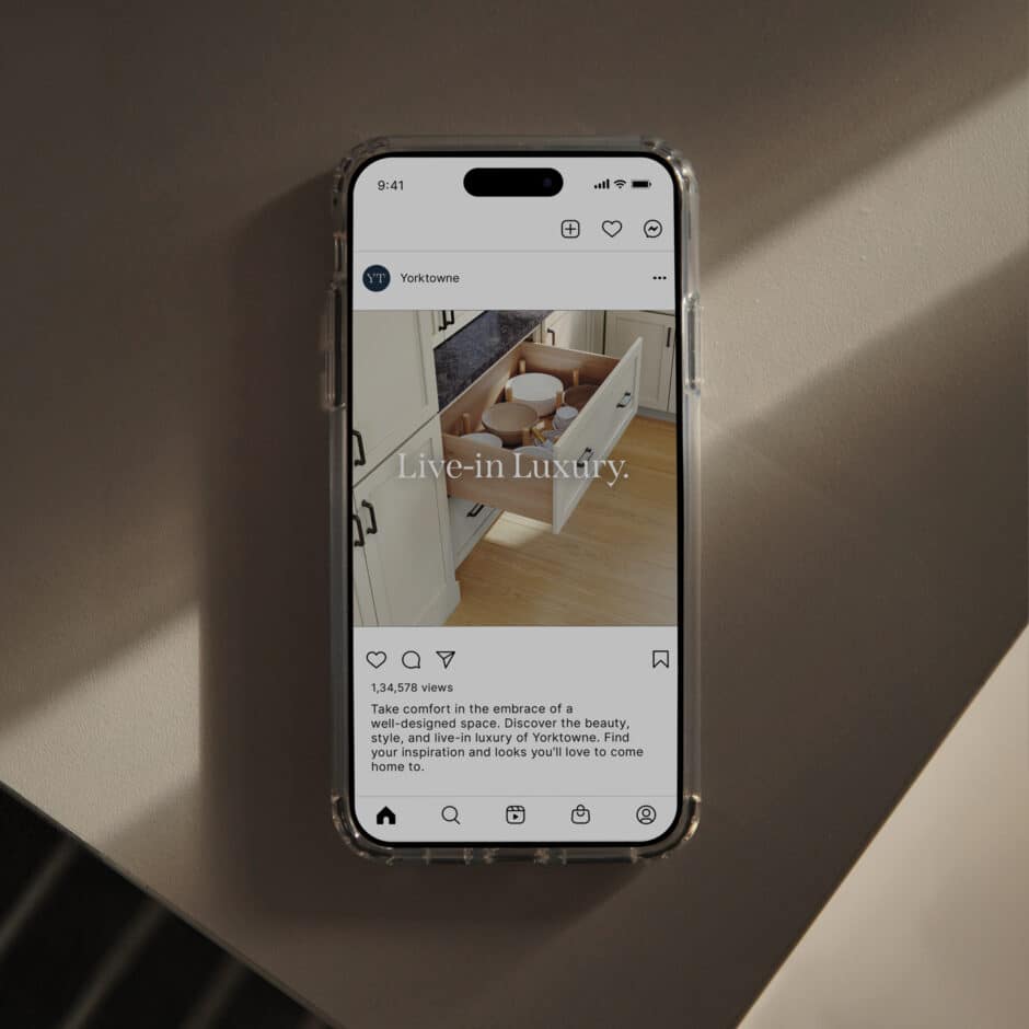 Smartphone displaying a social media post with an image of open kitchen drawers and text "Live-in Luxury." Captures elegance and modern design.