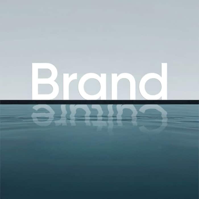 Minimalist seascape with the word “Brand” in large white letters above the horizon, mirrored in calm blue water under a pale sky.