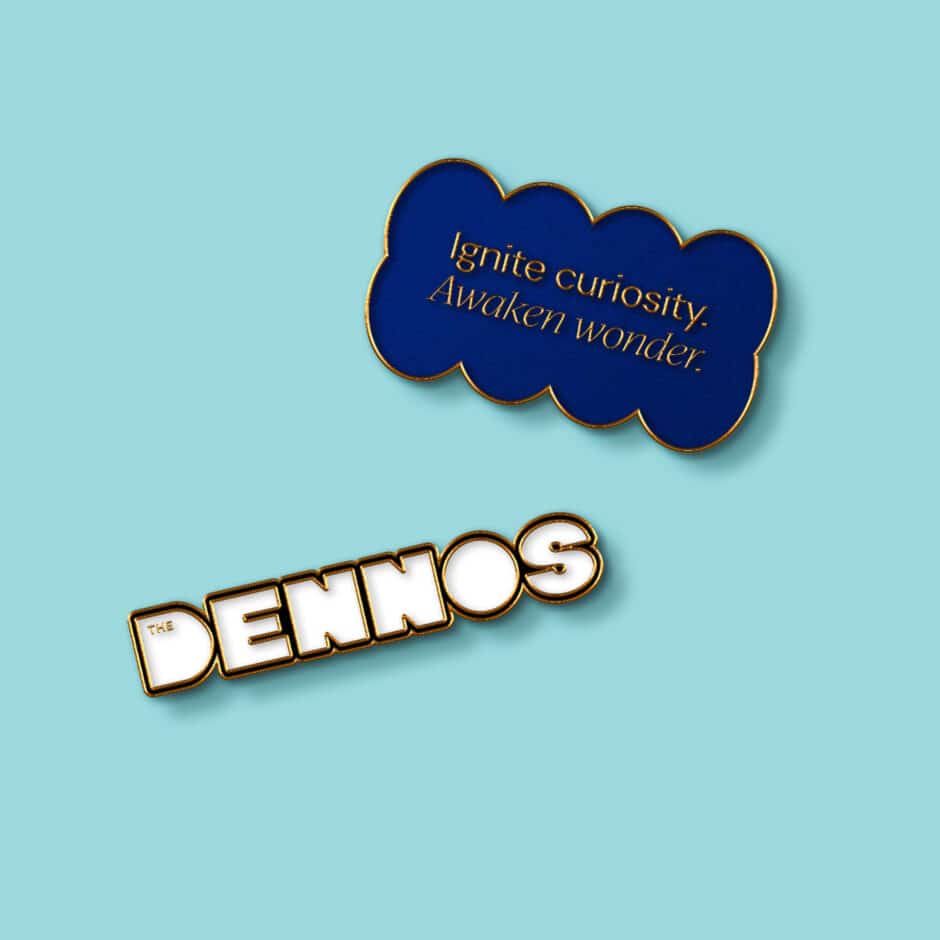 Playful graphic on a turquoise background: a navy cloud says “Ignite curiosity. Awaken wonder,” above bold 3D text reading “DENNOS.”