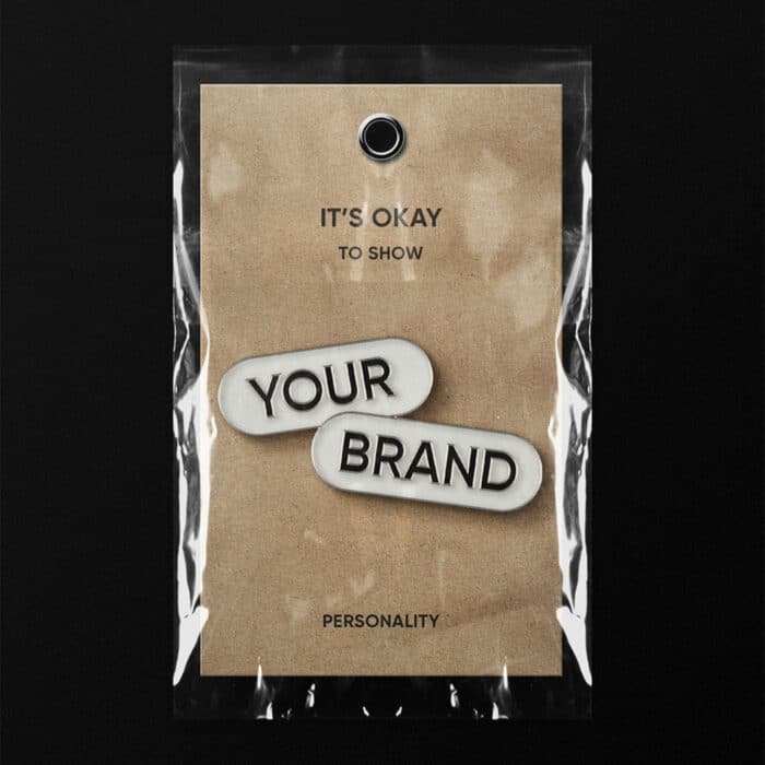 Vintage-style packaged tag on a dark background reads “It’s okay to show your brand personality,” with raised labels spelling “YOUR BRAND.”