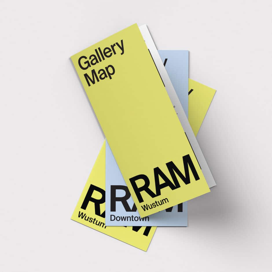 Stacked yellow and blue gallery map brochures on a light background, featuring bold black typography and a clean, modern design.